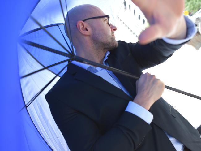 Dragi Stojanovski, Snezana’s husband, hides behind an umbrella as he leaves the Melbourne Coroners Court. Picture: Nicole Garmston