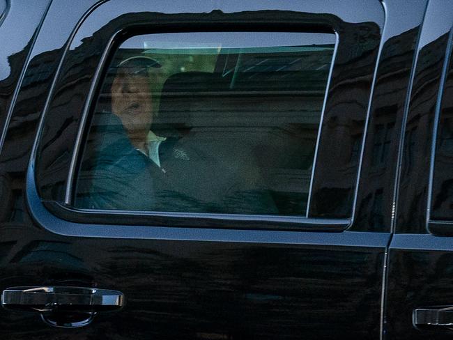 Mr Trump watches from the motorcade as he returns to the White House after his game of golf. Picture: AFP