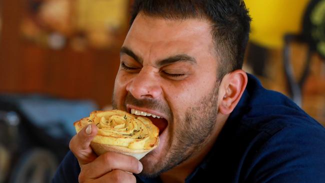 Glenorie Bakery owner Rob Pirina bites into the Invictus Pie in Glenorie. Pic: AAP Image / Angelo Velardo