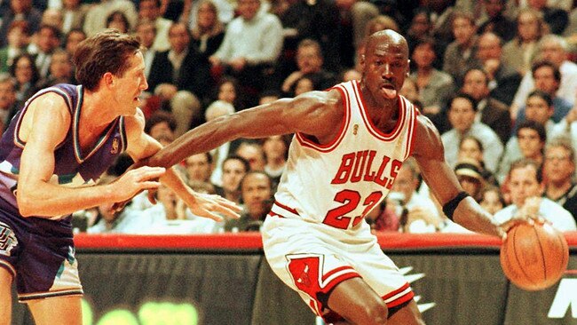 Chicago Bulls player Michael Jordan sticks out his tongue as he goes past Jeff Hornacek of the Utah Jazz during game two of the NBA Finals at the United Center in Chicago.