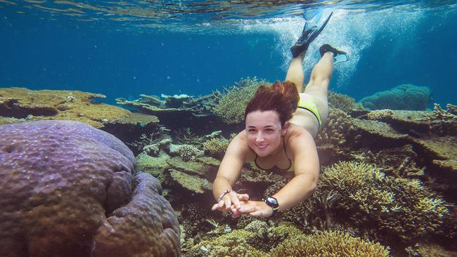 Heather Baird, 24-year-old dive master from the reef boat Calypso, swims among the corals at Opal reef on the Great Barrier Reef off the coast of Port Douglas. Picture: Brian Cassey/The Australian