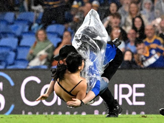 Streaker, Javon Johanson, is tackled by a security guard at Cbus Super Stadium. Picture: Getty Images