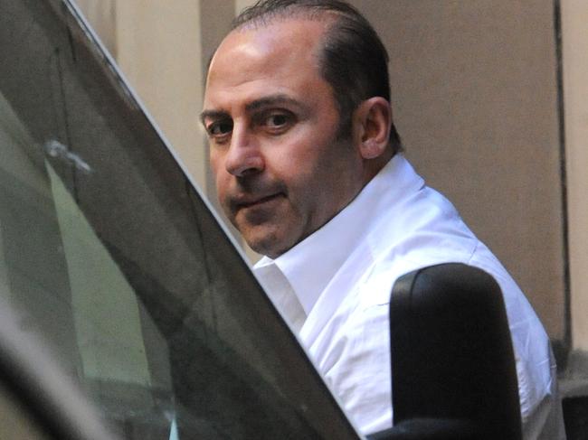 Underworld figure Tony Mokbel is lead into a prison van at the Supreme Court in Melbourne, Tuesday, Oct 18, 2011. Mokbel has applied to change his plea on drugs charges from guilty to not guilty. (AAP Image/Julian Smith) NO ARCHIVING