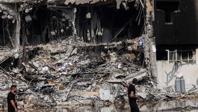 People walk past an Israeli police station in Sderot after it was damaged during battles to dislodge Hamas militants who were stationed inside on Sunday. Picture: Ronaldo Schemidt/AFP