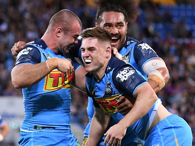 A J Brimson of the Titans (centre) reacts after scoring a try  ahead of Billy Slater of the Storm during the Round 24 NRL match between the Gold Coast Titans and the Melbourne Storm at Cbus Super Stadium on the Gold Coast, Saturday, August 25, 2018. (AAP Image/Dave Hunt) NO ARCHIVING, EDITORIAL USE ONLY