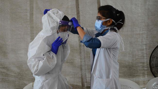 An health worker into her Personal Protective Equipment as she prepares to conduct a Covid-19 test on bus passengers at a testing camp in Sanathal, on the outskirts of Ahmedabad. Picture: AFP