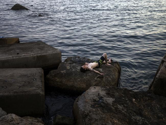 A man rests in front of the sea during a hot summer day in Barcelona. Picture: Emilio Morenatti