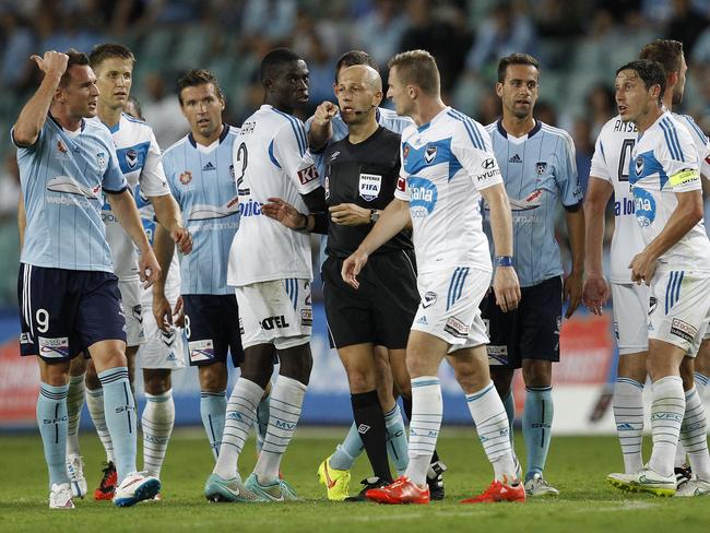 Referee Strebre Delovski (centre) gets between the Sydney and Melbourne players as tempers flare.