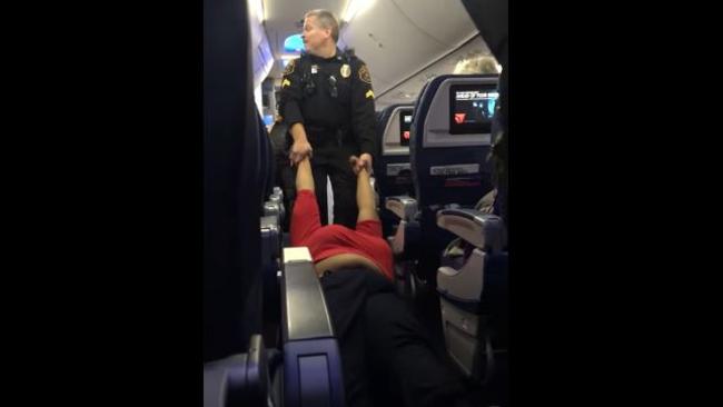 Officers dragged the woman in red off the plane by her wrists. Picture: YouTube