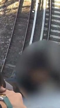 Teen caught dangling over active train tracks