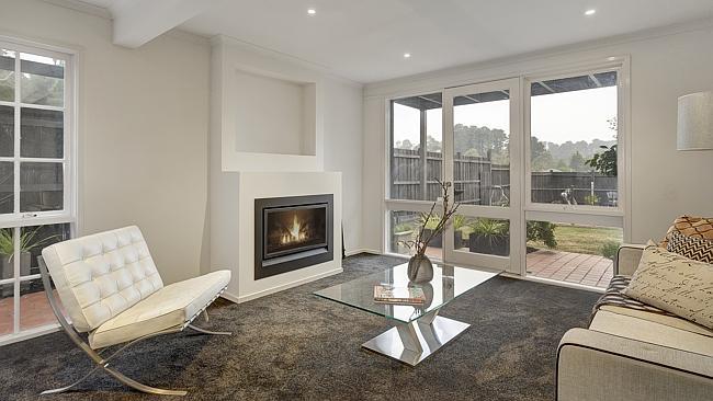 The formal living area with a glowing gas fireplace.