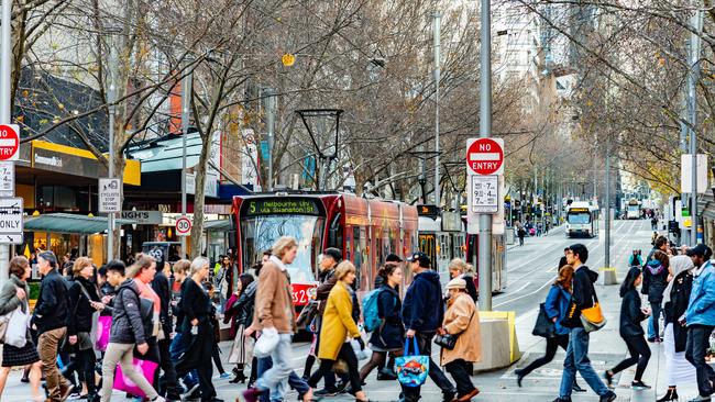 Pedestrians cross the road at the intersection of Bourke Street in Melbourne.