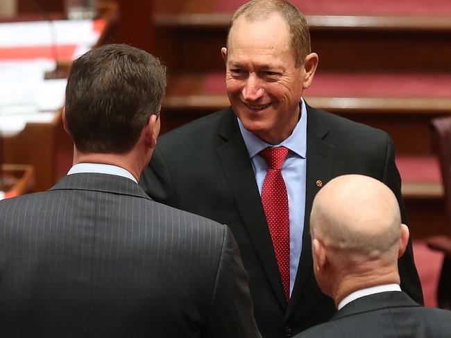New Senator Fraser Anning after being sworn in shaking hands with Senator Cory Bernardi and Senator David Leyonhjelm in the Senate Chamber, Parliament House in Canberra. Picture Kym Smith