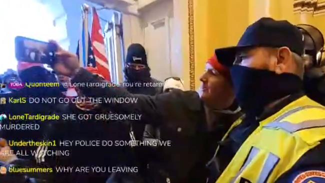 A US Capitol building police officer poses for a selfie with one of the insurrectionists who helped storm the US Capitol building.