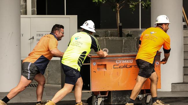 Workers leave the Probuild worksite on 443 Queens St. Picture: Zak Simmonds