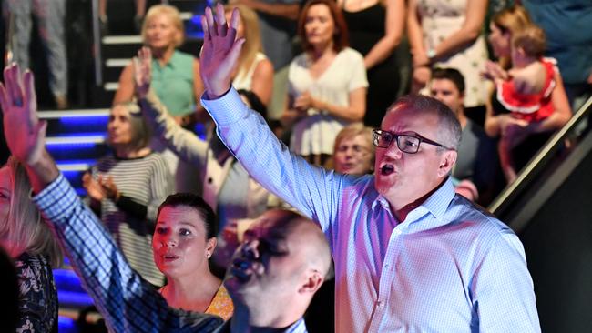 Prime Minister Scott Morrison and wife Jenny sing during an Easter Sunday service at the Horizon Church at Sutherland in Sydney.