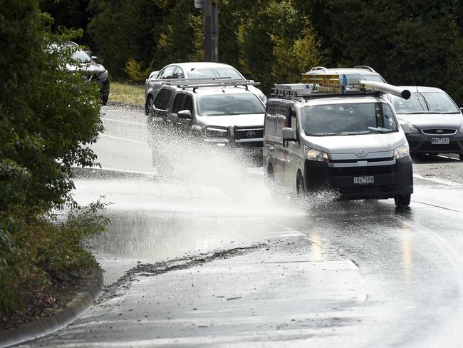 Cars drive through floodwaters in Ringwood after heavy rain hit the state. Picture: Andrew Henshaw