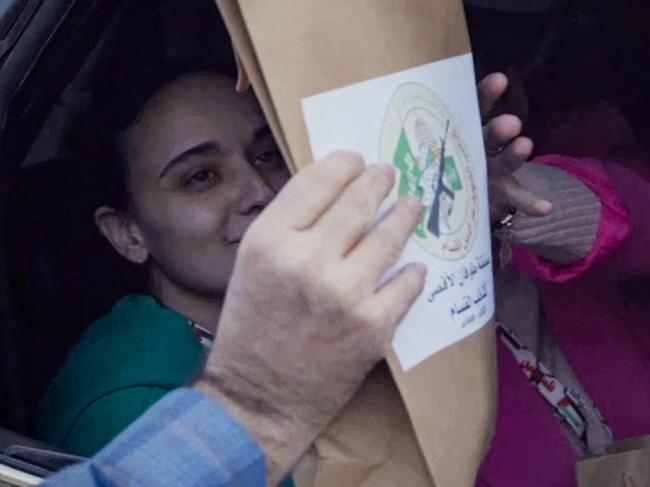 This image grab from a handout video released by the Hamas Media Office shows Israeli hostage Emily Damari (L) and Romi Gonen, who were abducted by Palestinian militants during the October 7, 2023 attacks, receiving a package bearing the logo of the the Ezzedine al-Qassam Brigades, Hamas's armed wing, as they sit in a Hamas vehicle before being handed over to the International Committee of the Red Cross (ICRC) in the Gaza Strip on January 19, 2025. The first three Israeli hostages were released on January 19 under a long-awaited Gaza truce aimed at ending more than 15 months of war that has ravaged the Palestinian territory. (Photo by HAMAS MEDIA OFFICE / AFP) / == RESTRICTED TO EDITORIAL USE - MANDATORY CREDIT "AFP PHOTO / HO / HAMAS MEDIA OFFICE" - NO MARKETING NO ADVERTISING CAMPAIGNS - DISTRIBUTED AS A SERVICE TO CLIENTS ==