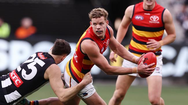 MELBOURNE - June 25 : AFL. Mitchell Hinge of the Crows looks to give as he is tackled by Jack Crisp of the Magpies during the round 15 AFL match between Collingwood and Adelaide at the MCG on June 25, 2023, in Melbourne. Photo by Michael Klein.