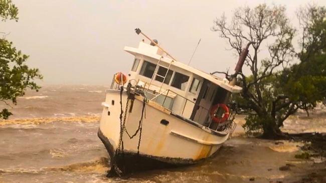 A bay cruiser washed up on the foreshore at Redland Bay during Cyclone Alfred. Picture: JUDITH KERR