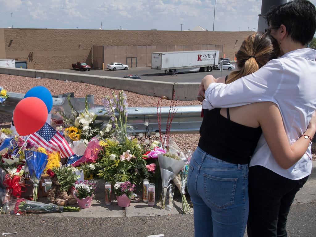 People hug beside a makeshift memorial outside the Cielo Vista Mall Walmart where a shooting left 22 people dead in El Paso, Texas. Picture: AFP