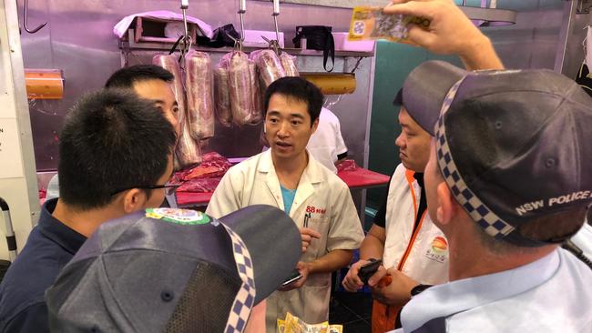 L&amp;C Butchery manager Ken Zhong shows police suspected counterfeit notes. Picture: Steven Deare