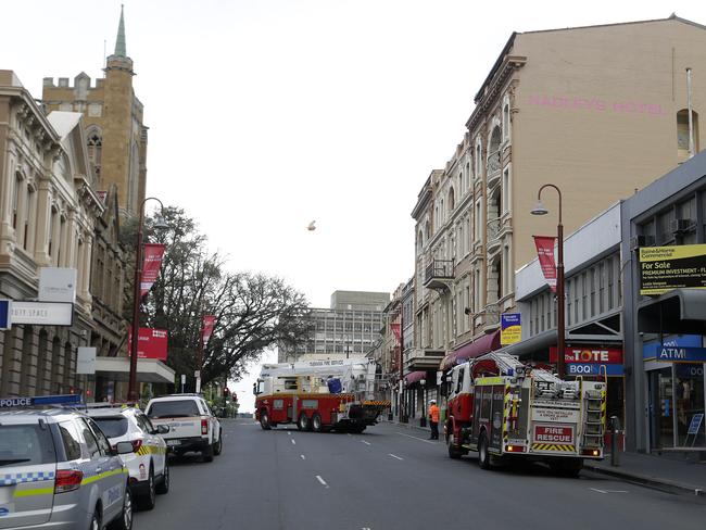 The Tasmania Fire Service inspects the damage to the roof of Hadleys Hotel. Some of the insulation can be seen flying through the air in the centre of the picture.