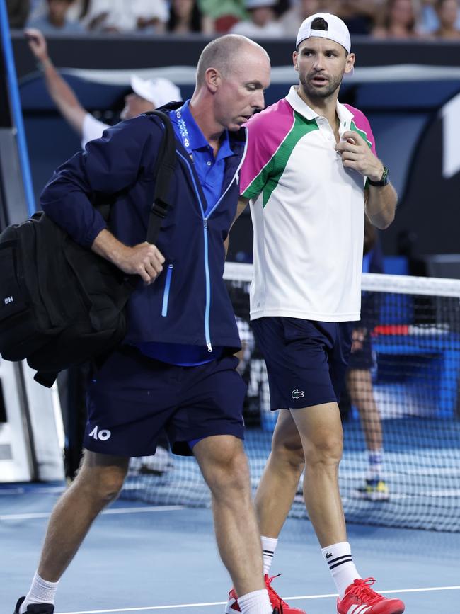 Dimitrov departs with the doctor. (Photo by Darrian Traynor/Getty Images)