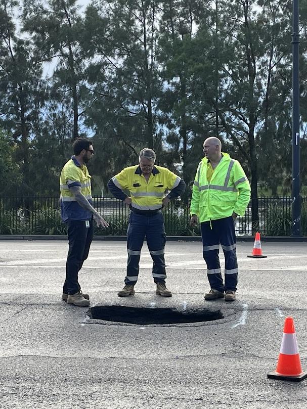 Workers look at a sink hole that formed on Coronation Drive at Auchenflower on Thursday morning. Picture: Andreas Nicola