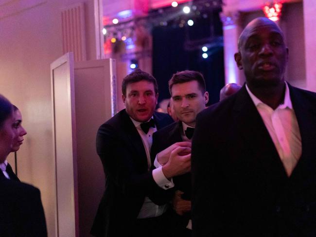 US political strategist Alex Bruesewitz (C) is escorted backstage after collapsing on stage while speaking during the New York Young Republican Clubâs Annual Gala at Ciprianiâs Wall Street in New York City on December 15, 2024. (Photo by Adam GRAY / AFP)