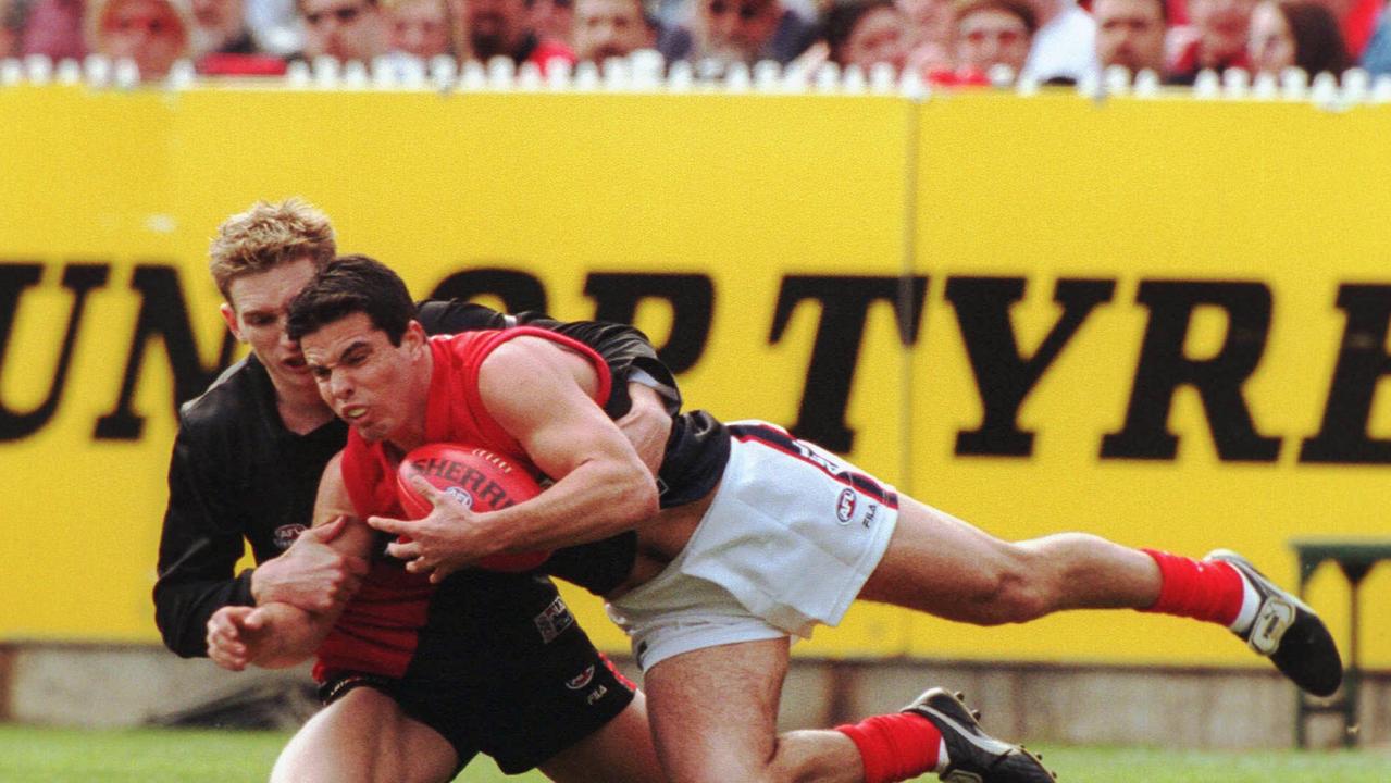 Guy Rigoni is brought down by James Hird in the 2000 grand final.