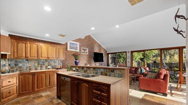 The expansive kitchen includes high-pitched ceilings and seamless flow to the living area.