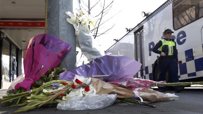 Residents lay flowers outside the North Hobart Grocer, where Voula Delios died. Picture: KIM EISZELE