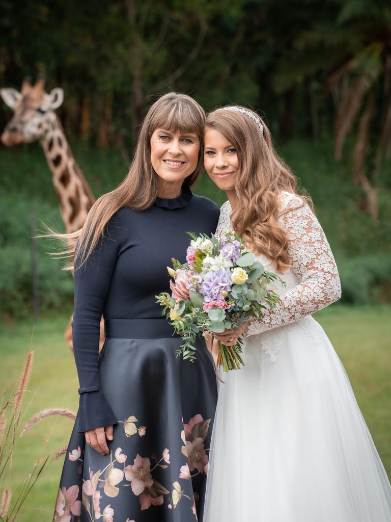 Terri Irwin and Bindi Irwin stand together. Giraffe in the background. Picture: Kate Berry