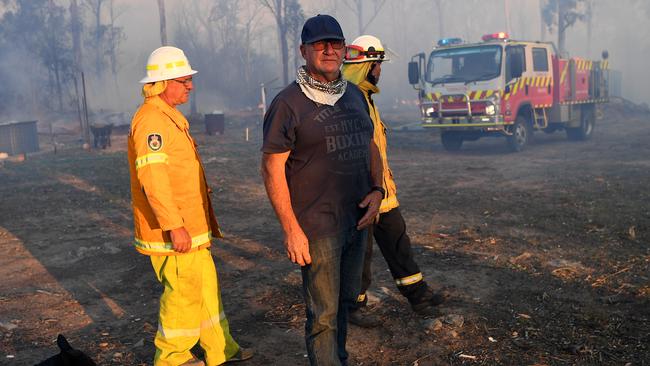 Geoff Hilton (centre) with volunteer firefighters who successfully defended his property in Torrington, near Glen Innes. Picture: AAP.