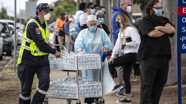 Health workers hand out water to the long queues of people at the Goulburn Valley Health Hospital in Shepparton. Picture: NCA NewsWire/Sarah Matray