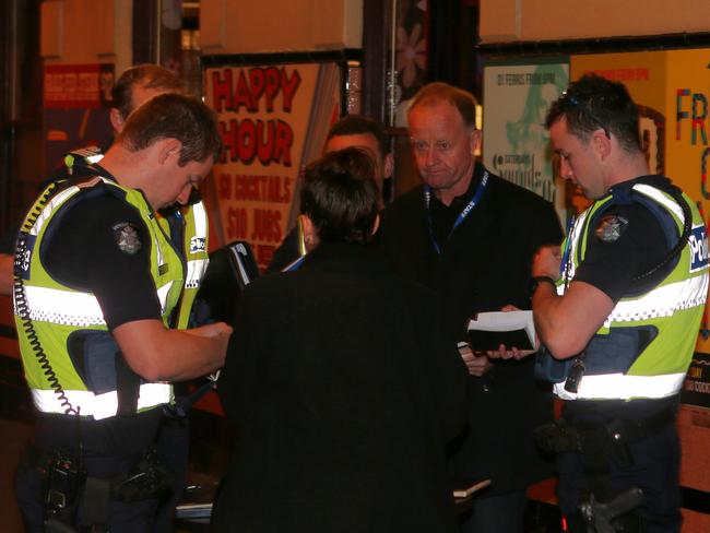 Police speak to people at the scene of the assault. Picture: David Crosling