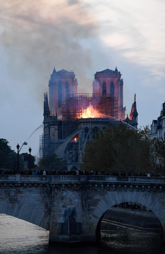Firefighters douse flames rising from the roof at Notre-Dame Cathedral in Paris on April 15, 2019. (Photo by Bertrand GUAY / AFP)