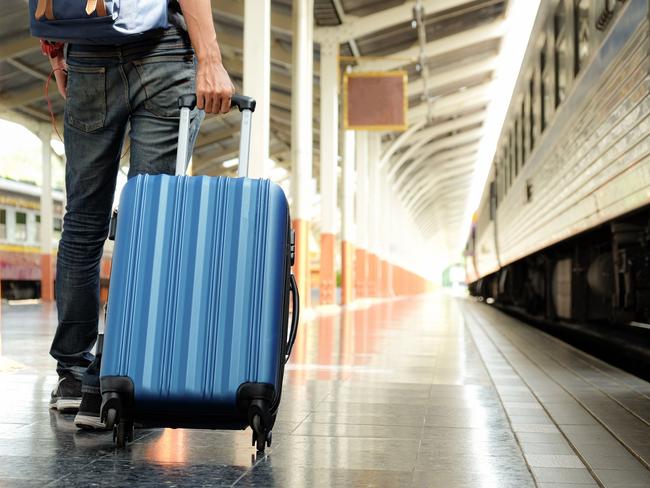 Traveller with suitcase on rail platform with train.Photo - GettyEscape 14 August 2022news