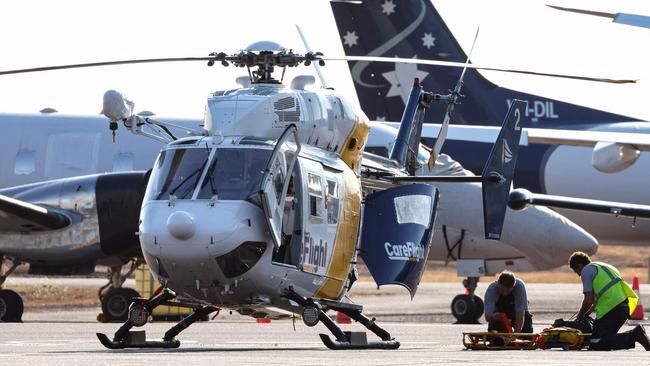 A Care Flight helicopter is seen on the tarmac of the Darwin International Airport in Darwin on Sunday, as rescue work is in progress to transport those injured in the US Osprey military aircraft crash. Picture: DAVID GRAY / AFP