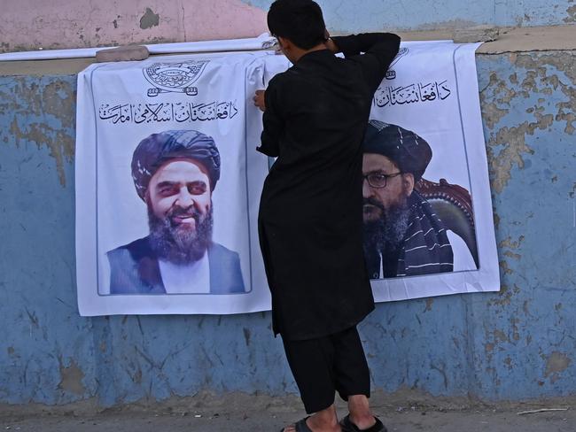 A vendor selling posters of Taliban leaders Mullah Abdul Ghani Baradar (R) and Amir Khan Muttaqi, waits for customers along a street in Kabul on August 27, 2021. Picture: Aamir Qureshi / AFP.