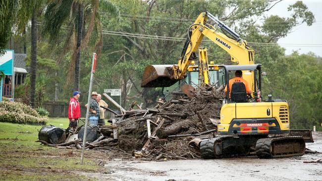 Heavy machinery is bought in to clean up debris on Hastings River Drive, Port Macquarie. Pic Nathan Edwards