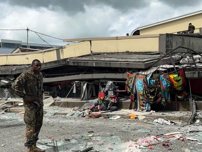 This screengrab taken from handout video footage posted on the Facebook account of Michael Thompson on December 17, 2024 shows a member of security inspecting a collapsed building in Vanuatu's capital Port Vila after a powerful earthquake hit the Pacific island. The 7.3-magnitude quake struck on December 17 at a depth of 57 kilometres (35 miles), some 30 kilometres off the coast of Efate, Vanuatu's main island, at 12:47 pm (0147 GMT), according to the US Geological Survey. (Photo by MICHAEL THOMPSON / Facebook account of Michael Thompson / AFP) / RESTRICTED TO EDITORIAL USE â MANDATORY CREDIT Â«AFP PHOTO / FACEBOOK / MICHAEL THOMPSONÂ» - NO MARKETING NO ADVERTISING CAMPAIGNS â DISTRIBUTED AS A SERVICE TO CLIENTS [- NO ARCHIVE ]