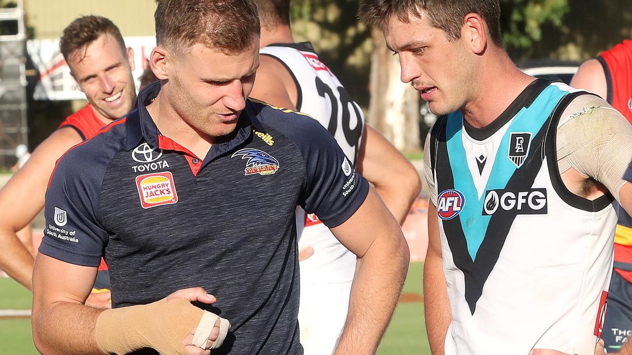 Rory Laird, with his hand bandaged, talks to Zak Butters post-game. Picture: Sarah Reed/AFL Photos