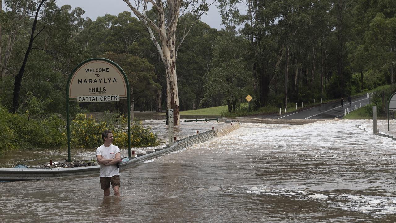 A person walks through fast moving flood waters at Cattai Creek in Maraylya. Picture: Brook Mitchell/Getty Images