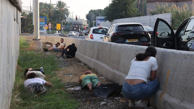 People take cover in Tel Aviv during a rocket attack from the Gaza Strip on Tuesday. Picture: AFP