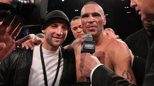 Cricketer Phil Hughes (left) poses with Anthony Mundine after Mundine defeated Daniel Geal to become the new IBO Middleweight World champion at the Brisbane Exhibition Centre on Wednesday, May 27, 2009. (AAP Image/Paul Harris) NO ARCHIVING