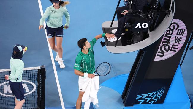 Fine to come? Novak Djokovic pats the feet of chair umpire Damien Dumosois on his way to victory in the Australian Open tennis men’s final last night. Picture: AFP