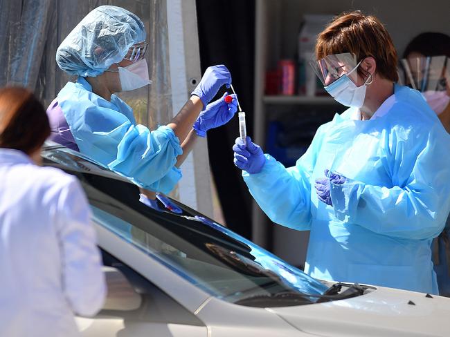 (FILES) In this file photo taken on March 12, 2020 Medical workers at Kaiser Permanente French Campus test a patient for the novel coronavirus, COVID-19, at a drive-thru testing facility in San Francisco, California on March 12, 2020. - Millions of San Francisco area residents on March 16, 2020 were ordered to stay home to slow the spread of the deadly coronavirus as part of a lockdown effort covering a section of California including Silicon Valley. (Photo by Josh Edelson / AFP)