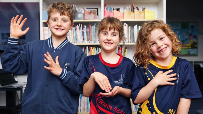 Theo, Henri and Patrick saying I am learning Auslan, in the sign language. Picture: Alan Barber